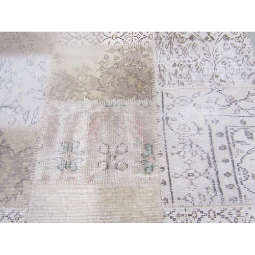 1560 - A Turkish patchwork carpet with patches of light browns with foliate detail on a backing, 242cm x 13... 