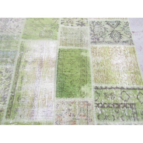 1562 - A Turkish patchwork carpet with patches in hues of green with abstract decoration, 243cm x 170cm.