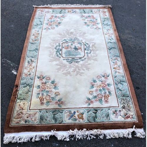 1593 - Chinese rug with traditional flower and bird design on a cream ground with green details and umber b... 