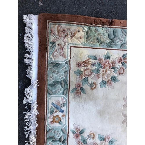 1593 - Chinese rug with traditional flower and bird design on a cream ground with green details and umber b... 