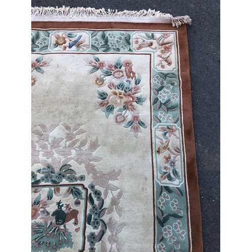 1593 - Chinese rug with traditional flower and bird design on a cream ground with green details and umber b... 