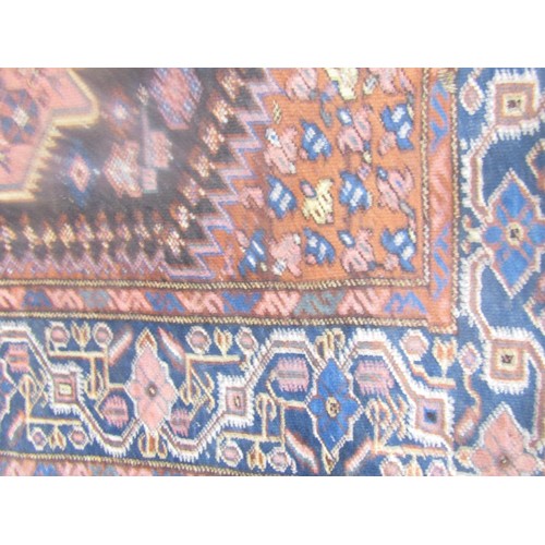 1579 - An antique Persian carpet with a shaped central medallion decorated with stylised flowers, with runn... 