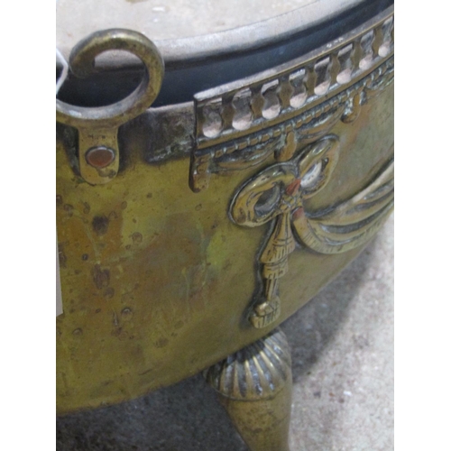 1165 - An oval brass planter with classical tied ribbon, swag and mask detail, removable liner and swept pa... 