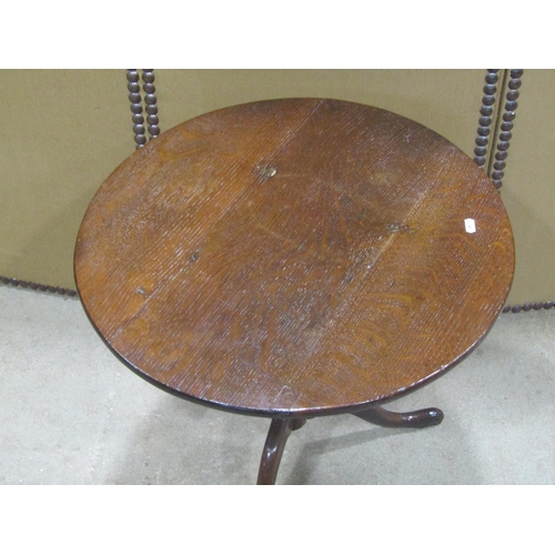 1169 - Two low oak occasional tables of circular form with turned pillars and swept tripods, 58 cm diameter... 