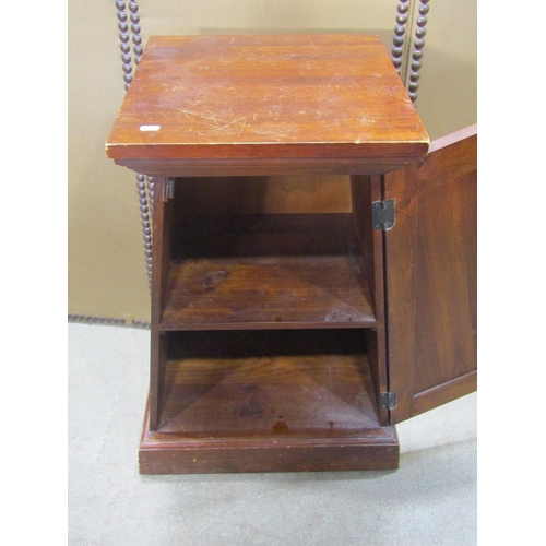 1189 - A small stained hardwood pedestal side cupboard, of tapered form, the stepped top above a panelled d... 