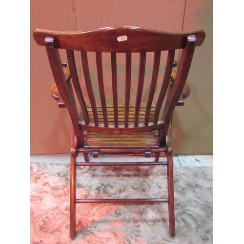 1244 - An Edwardian  folding chair with shaped arms, slatted seat and rail back