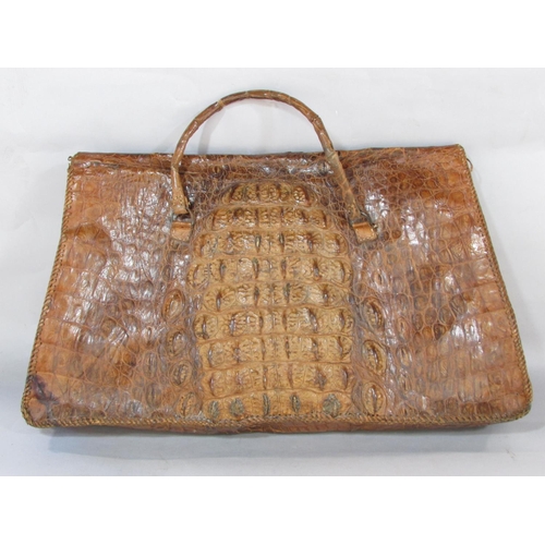 619 - A crudely made crocodile skin bag with a division to interior 54cm wide x 34cm approx.