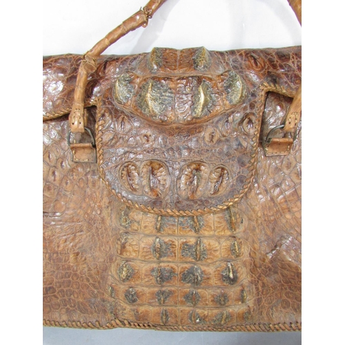 619 - A crudely made crocodile skin bag with a division to interior 54cm wide x 34cm approx.