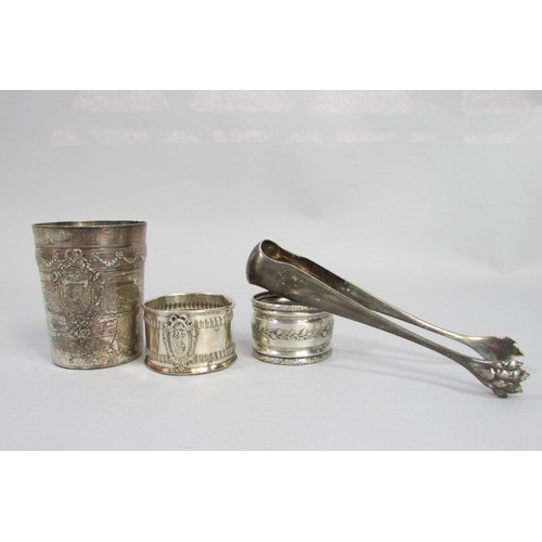 255 - A silver French beaker, bearing the head of Minerva, two napkin rings, a clawed sugar tong, three as... 