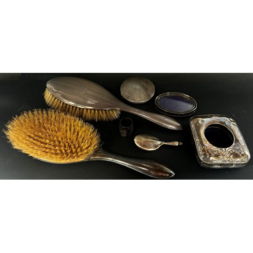 233 - A mixed selection of silver, two hairbrushes, a clock case, compactum, oval frame, collar and pendan... 