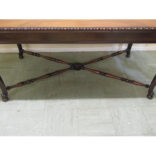 1399A - A walnut dining table of rectangular form with figured top and moulded edge raised on scrolled cabri... 