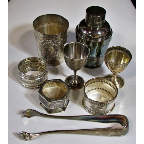 255 - A silver French beaker, bearing the head of Minerva, two napkin rings, a clawed sugar tong, three as... 