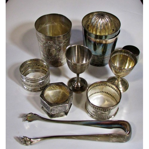 255 - A silver French beaker, bearing the head of Minerva, two napkin rings, a clawed sugar tong, three as... 