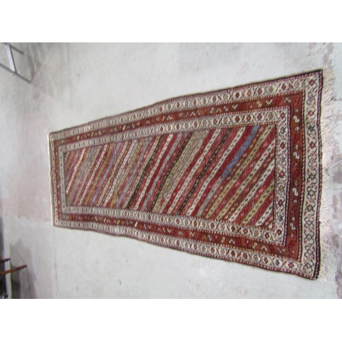 1559 - A Kurdish carpet with diagonal repeating stripes, 266cm x 108cm