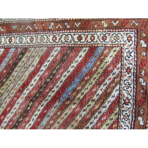 1559 - A Kurdish carpet with diagonal repeating stripes, 266cm x 108cm