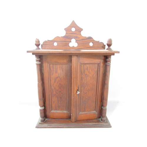 535A - A Victorian pitch pine cabinet, with acorn finials to the cornice over two panelled doors flanked by... 