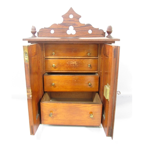 535A - A Victorian pitch pine cabinet, with acorn finials to the cornice over two panelled doors flanked by... 