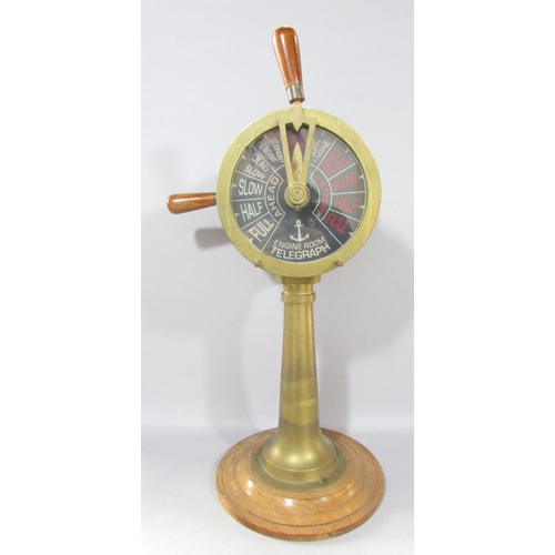 538A - A brass ship’s engine room Telegraph set on a circular wood base, still in working, 53cm tall togeth... 