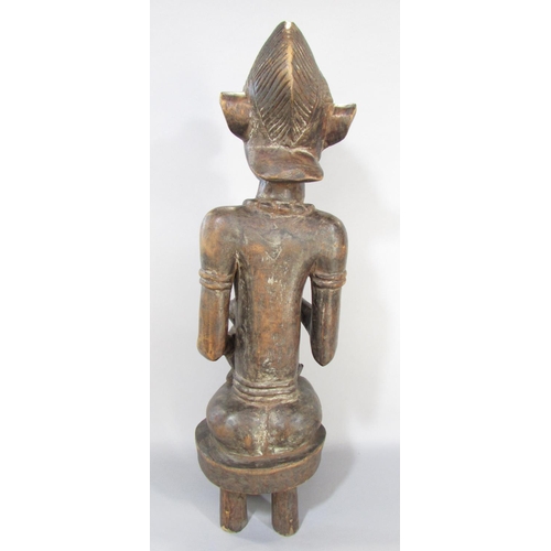 643A - An African carving in the Congolese style of a woman breast feeding a baby, 66cm high.