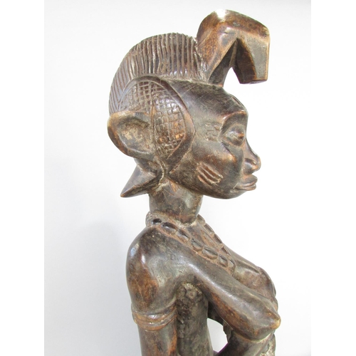 643A - An African carving in the Congolese style of a woman breast feeding a baby, 66cm high.