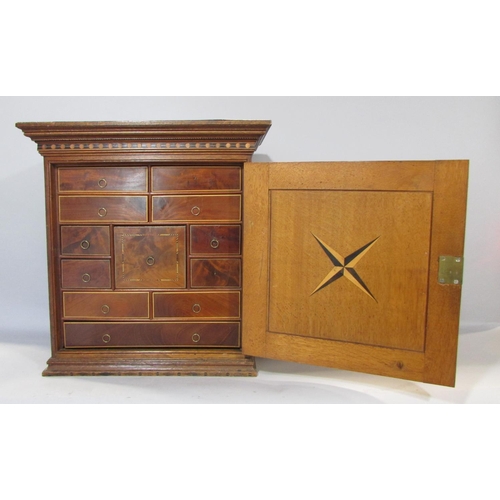 648A - A 19th century collectors cabinet in oak with mahogany banding, the door opening to reveal a selecti... 