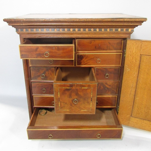 648A - A 19th century collectors cabinet in oak with mahogany banding, the door opening to reveal a selecti... 