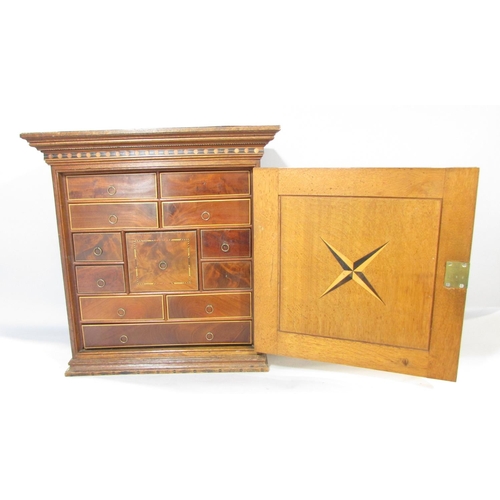 648A - A 19th century collectors cabinet in oak with mahogany banding, the door opening to reveal a selecti... 