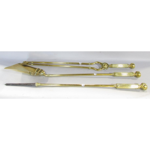 648B - A set of three Victorian brass fire irons, poker, shovel and tongs, each with reeded handles