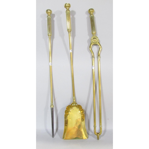 648B - A set of three Victorian brass fire irons, poker, shovel and tongs, each with reeded handles