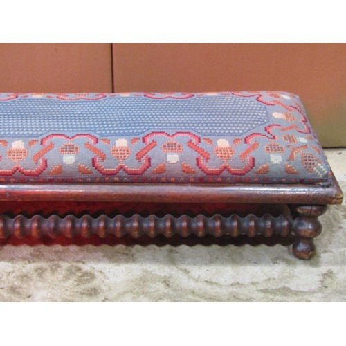 1239 - A long upholstered Victorian foot / hearth stool, with bobbin turned rails, 121 x 28cm