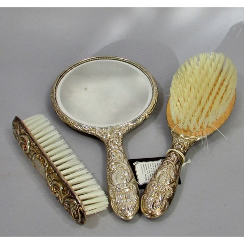 232 - An early 20th century silk lined box with a silver hair brush set, a hand mirror, hair and clothes b... 