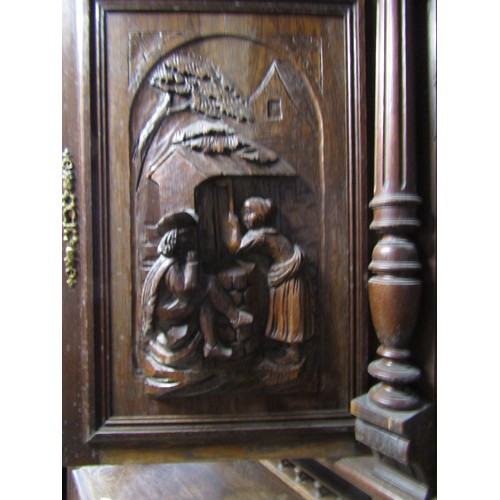 1293 - A continental oak buffet enclosed by an arrangement of cupboards and drawers with carved detail flan... 