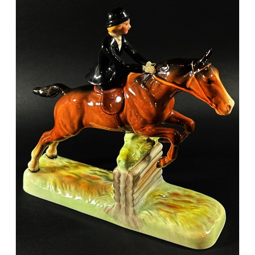 59 - A Beswick equestrian figure group of a woman riding side saddle jumping a fence