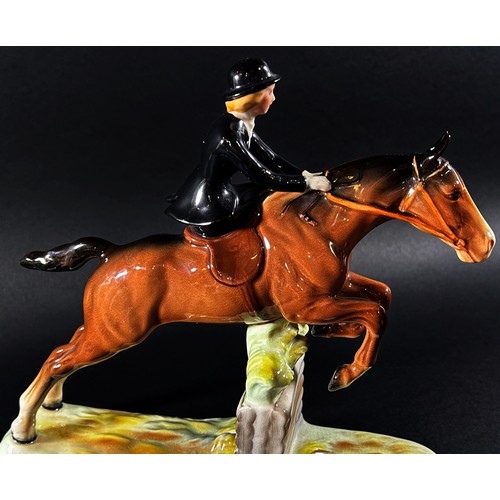 59 - A Beswick equestrian figure group of a woman riding side saddle jumping a fence