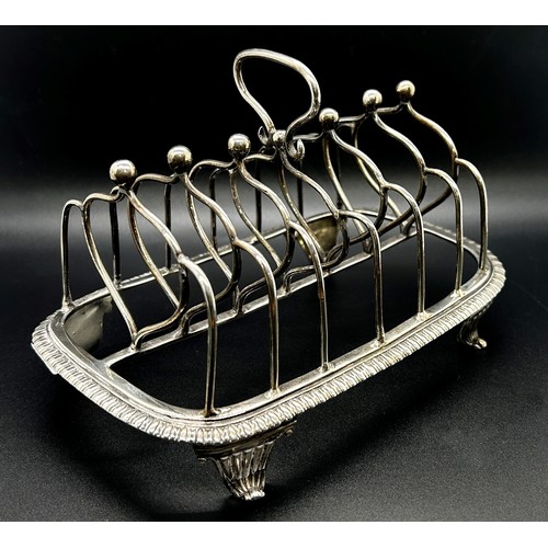 172 - A George III silver toast rack with six heart shaped divisions, gadrooned base on scrolled feet, Lon... 