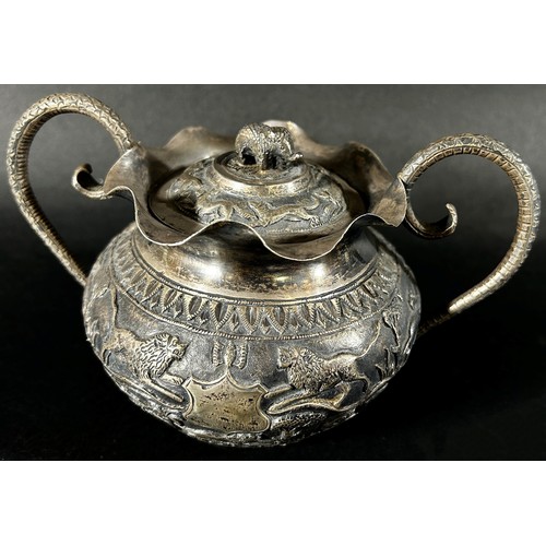 179 - A middle eastern silver metal bowl with cover and serpent handles decorated with lions, gazelles and... 