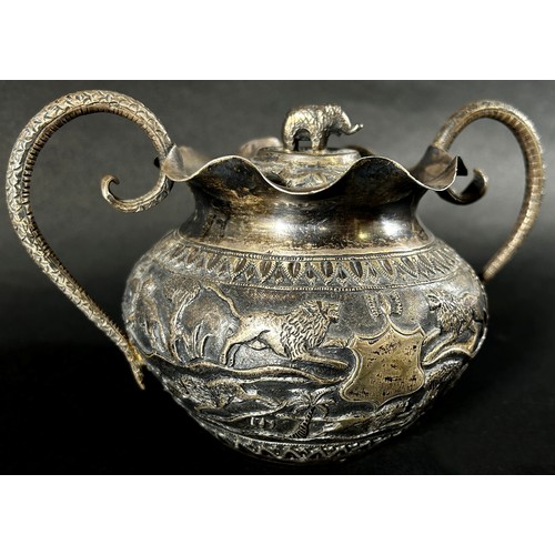 179 - A middle eastern silver metal bowl with cover and serpent handles decorated with lions, gazelles and... 