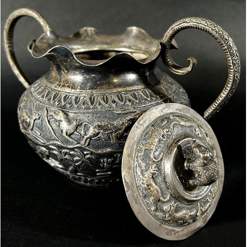 179 - A middle eastern silver metal bowl with cover and serpent handles decorated with lions, gazelles and... 