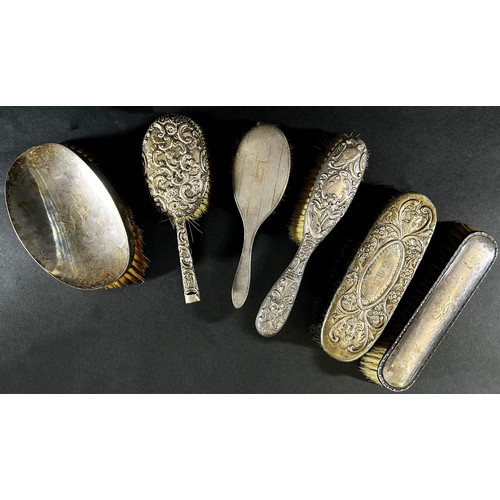 182 - Six assorted silver backed dressing table brushes and a cut glass bottle with a sterling collar, plu... 