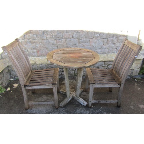 1015 - A small weathered teak terrace table with circular slatted top raised on tapered supports united by ... 