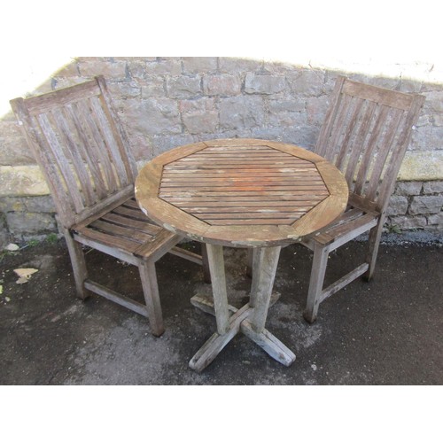 1015 - A small weathered teak terrace table with circular slatted top raised on tapered supports united by ... 