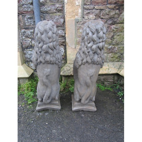 1014 - A pair of cast composition stone pier/garden ornaments in the form of seated lions clutching armoria... 