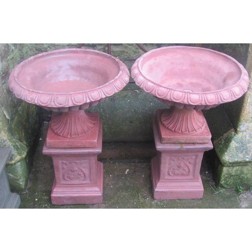 1032 - A pair of cast composition stone garden urns, the flared squat circular lobbed bowls with flared egg... 