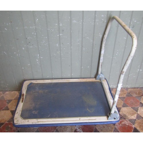 1037 - A well used but useful four wheeled platform trolley with sprung tubular steel handle, the bed 87 cm... 