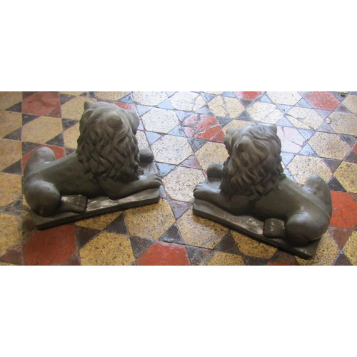 1048 - A pair of cast composition stone recumbent lions 33 cm high x 40 cm long x 20 cm wide