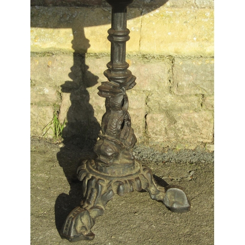 1070 - Pair of circular wooden topped pub tables raised on cast iron bases with entwined stylised dolphin d... 