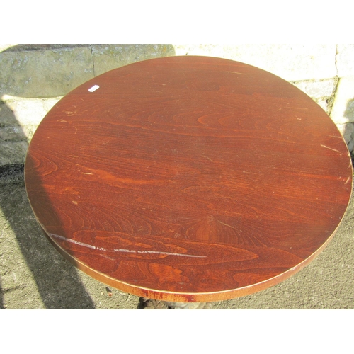 1071 - Pair of circular wooden topped pub tables raised on cast iron bases with entwined stylised dolphin d... 