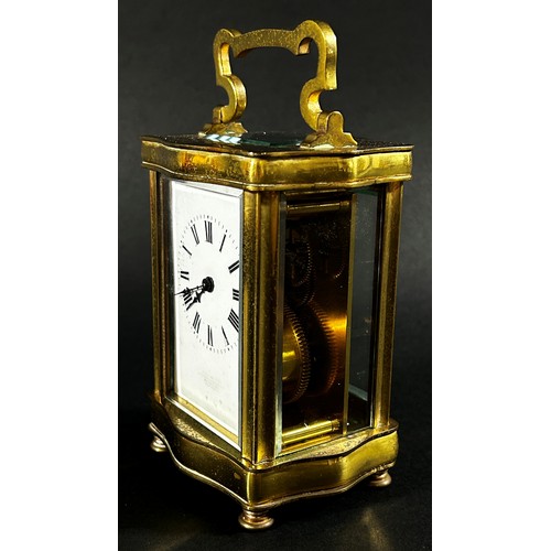 442 - A brass carriage clock set within a shaped case with enamelled dial and eight day timepiece, current... 