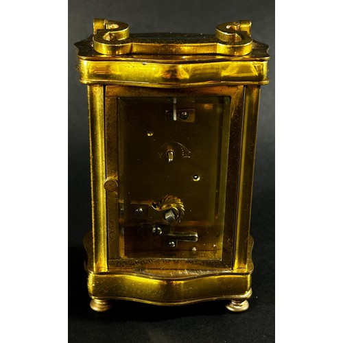 442 - A brass carriage clock set within a shaped case with enamelled dial and eight day timepiece, current... 