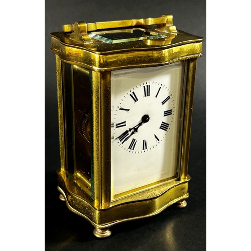 442 - A brass carriage clock set within a shaped case with enamelled dial and eight day timepiece, current... 